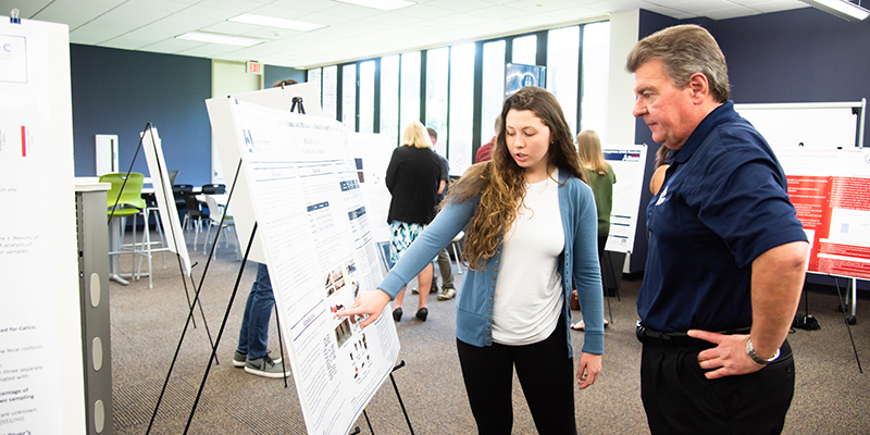 Female Student Presenting Research poster