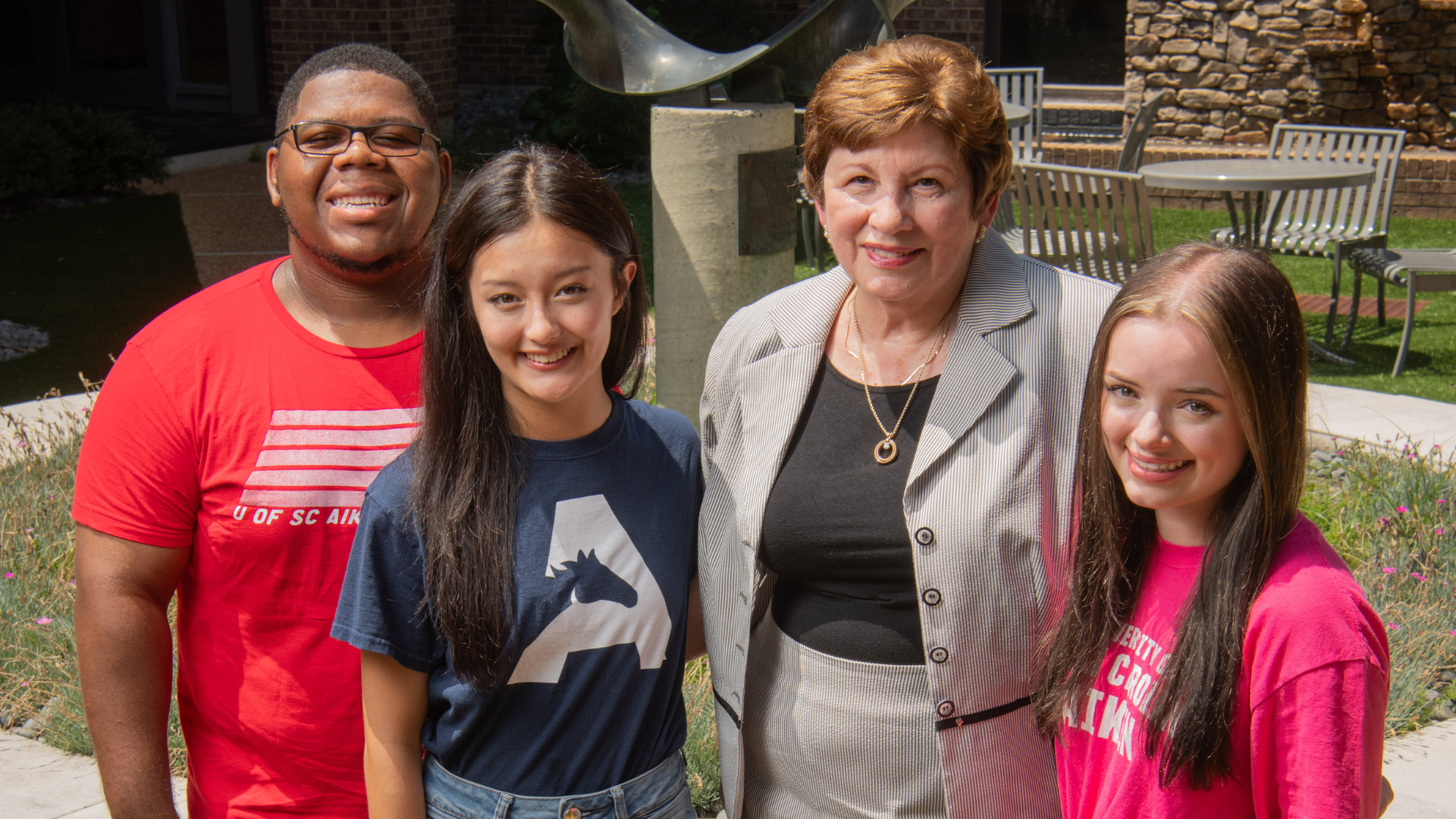 Group of students pose for photo with Liz Stewart.