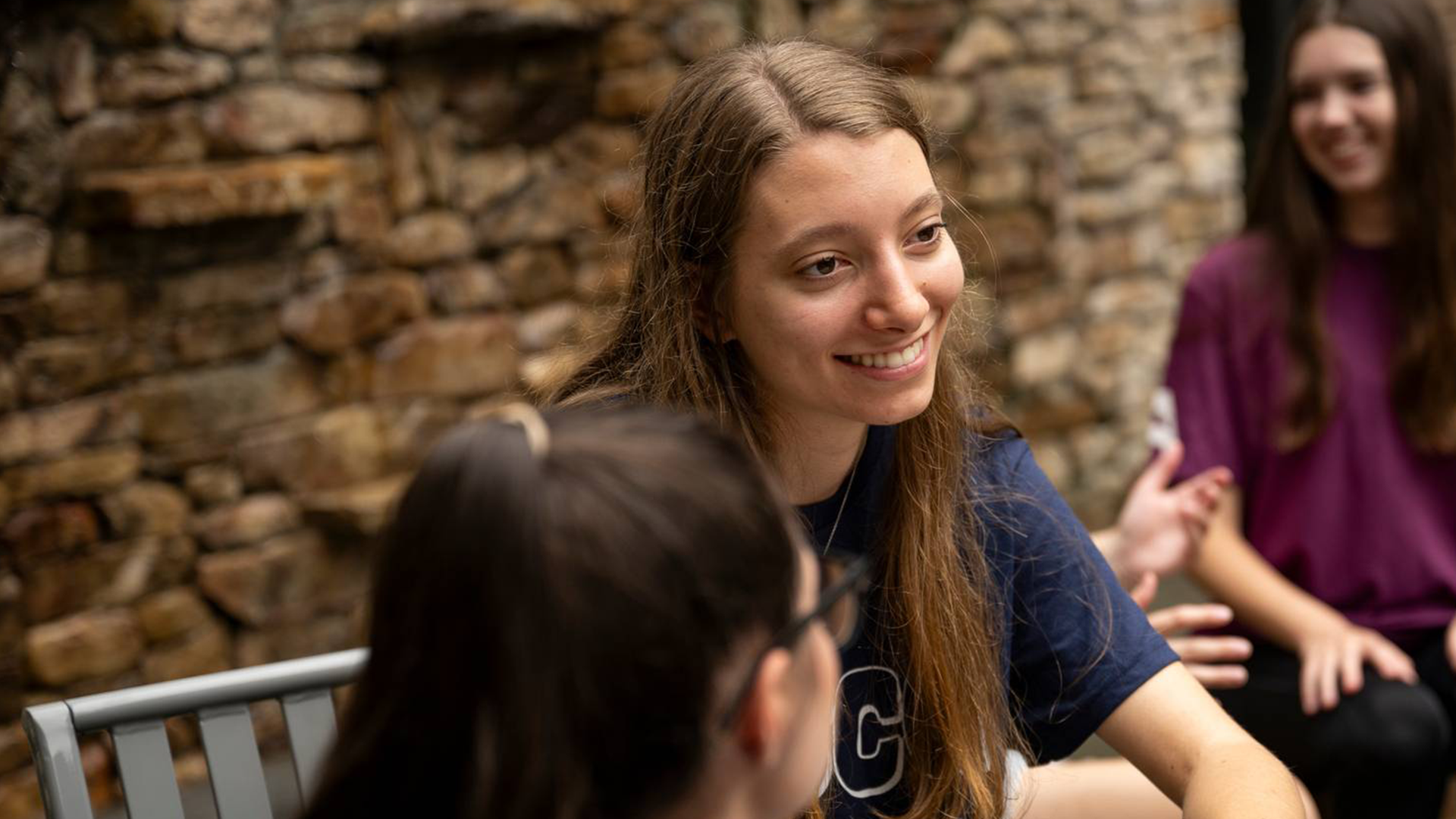 Student smiles while talking to another student